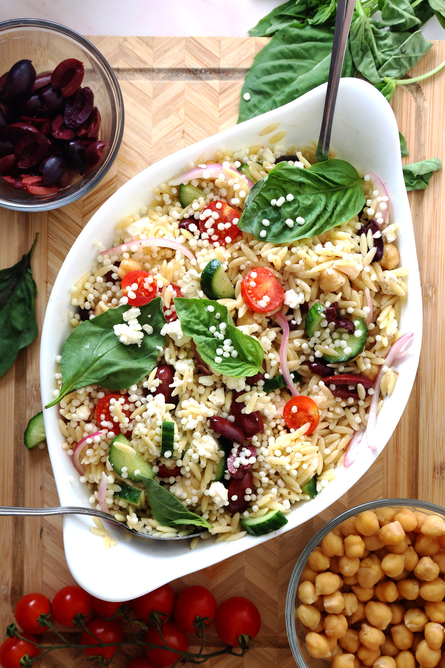 Orzo salad with tomatoes, cucumber, olives, chickpeas, and feta topped with LIFTER Crispies
