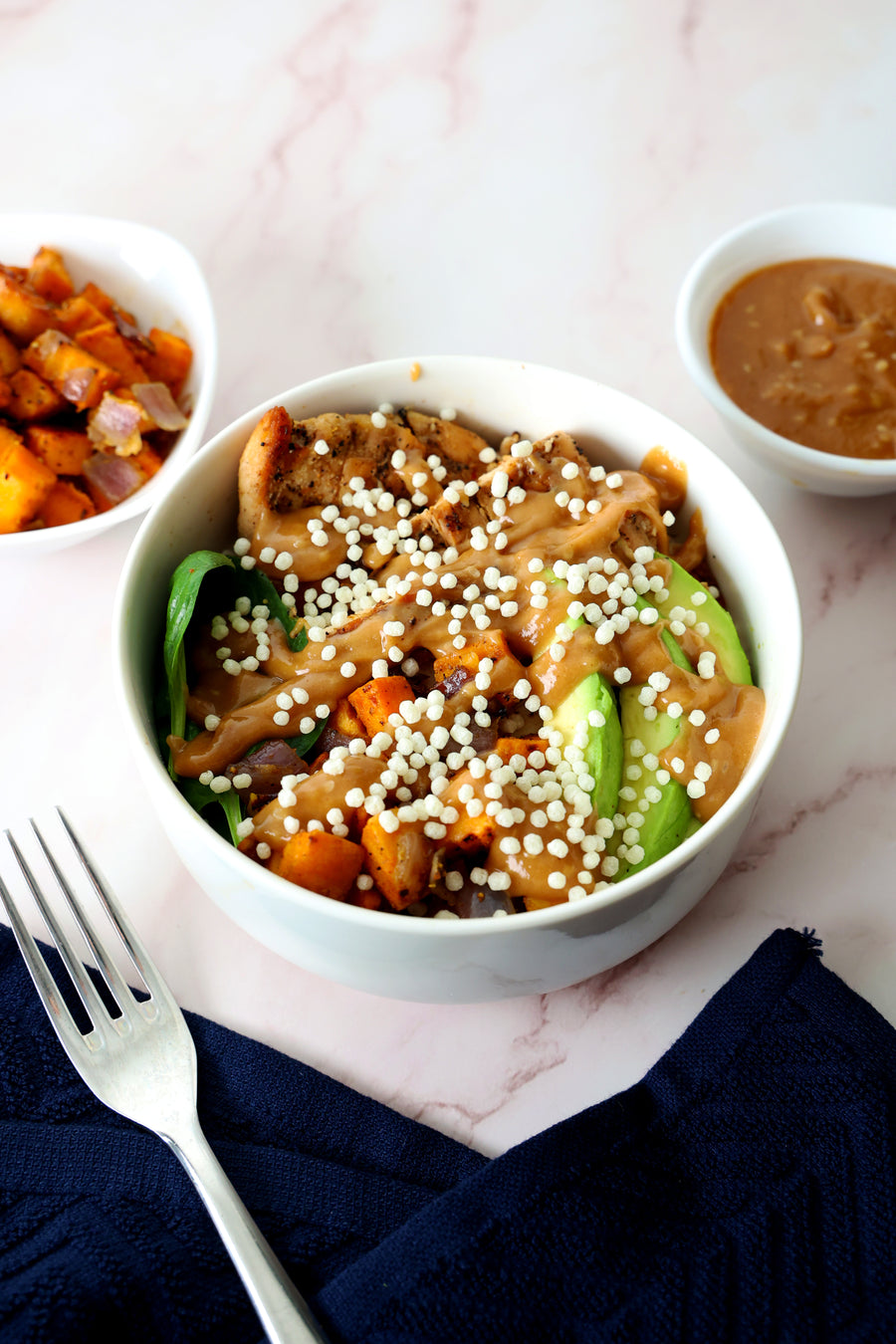 Protein bowl with roasted sweet potato, greens, avocado, and peanut sauce topped with LIFTER Crispies
